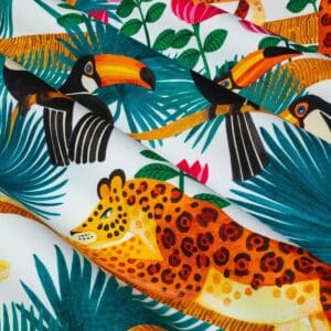 Toucans, stoff med leoparder og tukaner på hvit bunn fra Maison THevenon